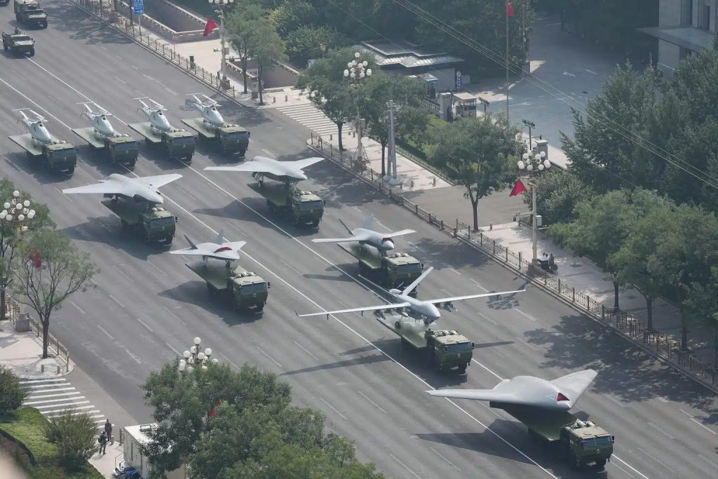 A lineup of China’s newest combat drones rolls through Beijing’s September parade—four jet-powered models up front, with four rotary drones trailing behind. (Chinese state media photo)